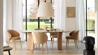 Lifestyle image of camel Mobitec Neo chairs at a round wooden table with a large pendant lamp