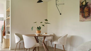 Lifestyle image of cream Mobitec Neo chairs at a round wooden table in a living room