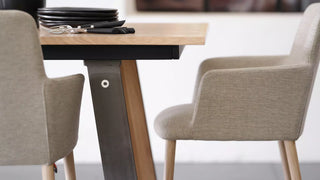 Detail of light grey Mobitec Rob armchairs at a wooden table with black base