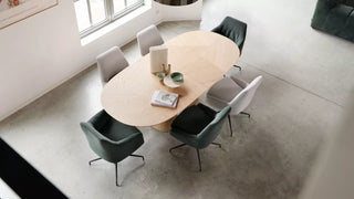 Sfeerbeeld van groene en grijze Mobitec Saga stoelen aan een ovale tafel, bovenaanzicht