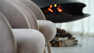Detail van ecru Mobitec Thalia fauteuils bij een open haard