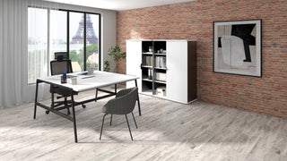 Lifestyle image of a white Buronomic Alto 146 cm cabinet by a desk against a brick wall