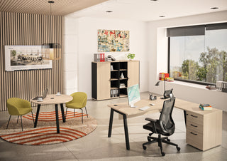 Lifestyle image of a Buronomic Comfort desk-height pedestal in wire oak as return in a bright office